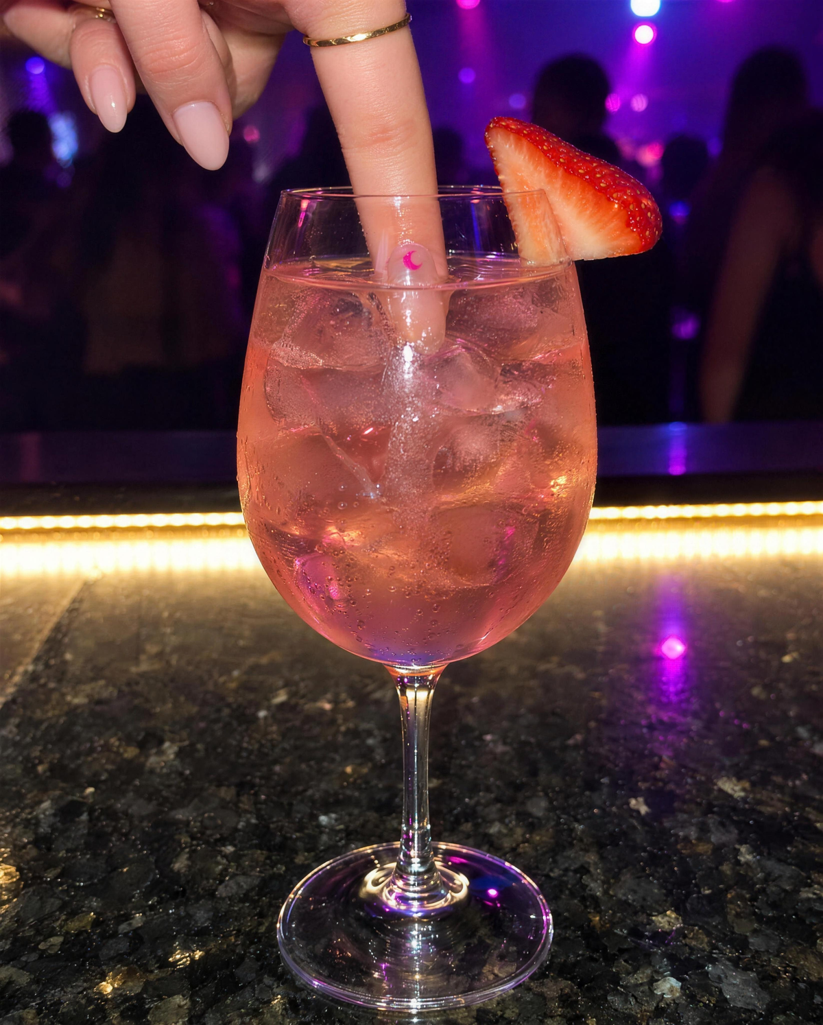 Dipping a fingertip with the sticker into a spritz at the bar